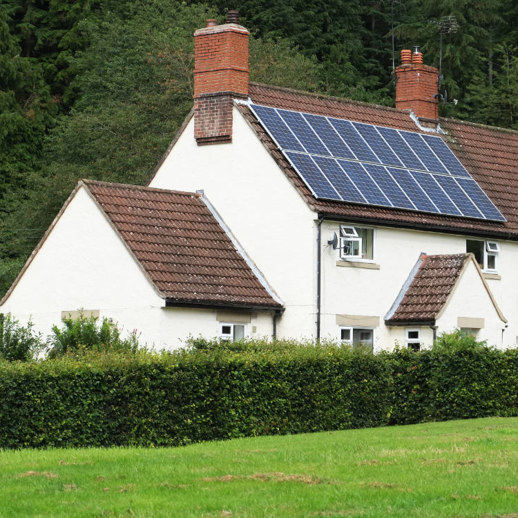 White cottage with solar panels on roof